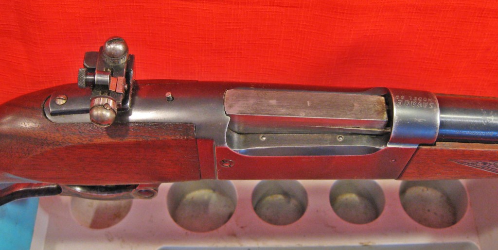 Bolt locked and even with receiver at rear.  Note cocking indicator peg in front of sight